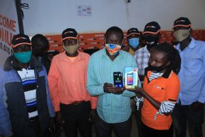 Fortebet operator (in orange) handing over a phone to a winner in Kapchorwa